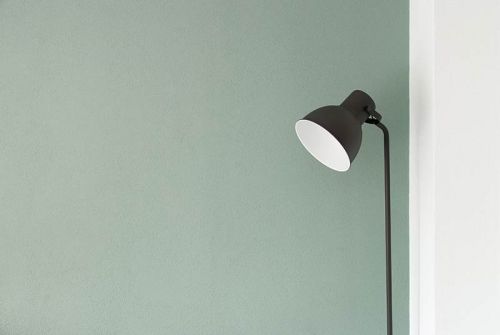 Detalle de lámpara de lectura sobre pared en tono verde